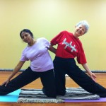 Radha and Sondra in a partnered Parighasana (Gate Pose)